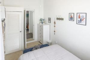 a white bedroom with a bed and a dresser at Annes Revenge The Bonney Overlook in Christiansted