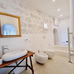 a bathroom with a sink and a toilet and a mirror at Corte Mercurio B&B in Ugento +182 photos