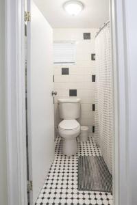 a bathroom with a toilet and a black and white tile floor at The Captains Quarters - A Relaxing Nautical Abode in Christiansted