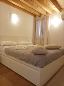 uma cama branca num quarto com uma janela em Ve-nice Suite Casa Teresa C881 em Veneza