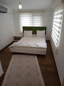a bedroom with a bed with white sheets and a rug at Terrasuit in Antalya
