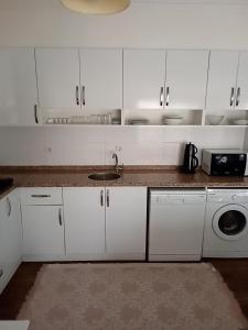 a white kitchen with a sink and a washing machine at Terrasuit in Antalya