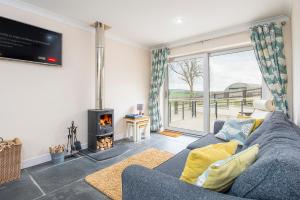 a living room with a blue couch and a fireplace at Luxury cottage with private INDOOR hot tub+woodlands in Llanfyrnach