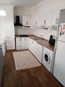 una cucina con mobili bianchi e un frigorifero bianco di Terrasuit a Antalya (Adalia) Altre 52 foto