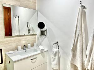 a white bathroom with a sink and a mirror at Luxury apartments in Marrakesh