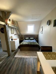 um pequeno quarto com uma cama e uma escada em Le petit Baroque em Auxerre