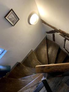 uma escada de madeira num quarto com luz em Le petit Baroque em Auxerre