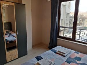 um quarto com uma cama e uma janela em 3 стаен апартамент идеален център Варна em Varna City