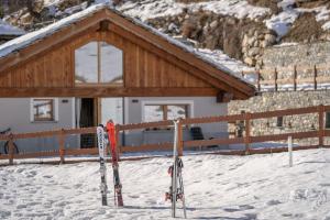 a group of skis in the snow in front of a building at FAIRWAY LODGE in Breuil-Cervinia