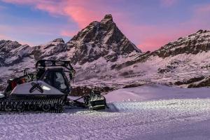 a snow bulldozer parked in front of a mountain at FAIRWAY LODGE in Breuil-Cervinia