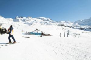 un grupo de personas esquiando por una pista cubierta de nieve en FAIRWAY LODGE, en Breuil-Cervinia