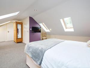 een slaapkamer met een groot wit bed en dakramen bij Carriage House in Penrith