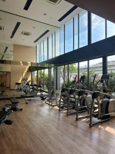 un gimnasio con un montón de pisadas y máquinas elípticas en HMJ3 Entire Apt on 33rd floor in Khonkaen city center en Khon Kaen