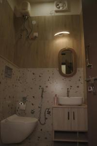 uma casa de banho com um lavatório, um WC e um espelho. em Bungalow Eleven11 em Jaipur