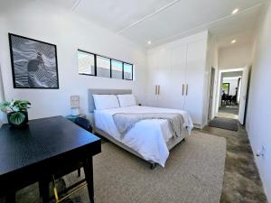 1 dormitorio con cama, mesa y piano en Private 2 Bed Guest Suite with Garden en Ciudad del Cabo