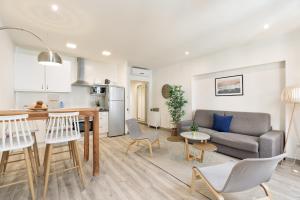 sala de estar y cocina con sofá y mesa en Sitges Group Blue&White, en Sitges