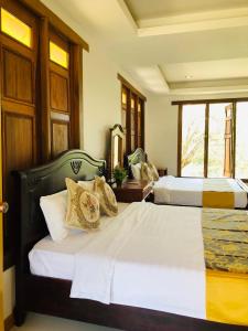 1 Schlafzimmer mit 2 Betten und einem Fenster in der Unterkunft Vang Vieng Romantic Place Resort in Vang Vieng