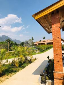 a walkway leading to a resort with mountains in the background at Vang Vieng Romantic Place Resort in Vang Vieng