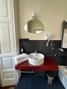 uma casa de banho com um balcão vermelho e um lavatório em Voglia 'e turnà em Nápoles