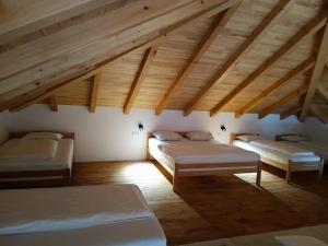 a attic room with three beds and wooden ceilings at Vikendica Krcmarice- Banja Luka in Banja Luka +47 photos