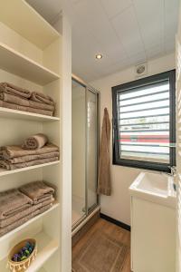 a bathroom with a shower and a sink and towels at Floatinghouses Weserbergland in Höxter