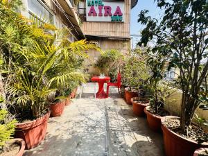 a patio with potted plants and a red bench at Staybook Hotel Aira, Paharganj, New Delhi Railway Station in New Delhi