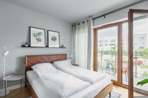 a bedroom with a bed and a large window at Studio w centrum- Villa Wenecja in Poznań