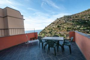 a table and chairs on a balcony with a mountain at Luxury Seaview Apartments Manarola by Arbaspàa in Manarola