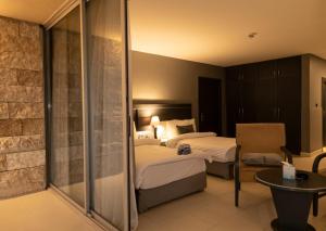 a hotel room with two beds and a table at O Beach Hotel & Resort in Sowayma
