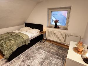 een kleine slaapkamer met een bed en een raam bij FlattyOne Ruhrgebiet - Schlafkomfort und Anbindung - neu renoviert in Bochum