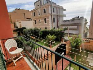 - un balcon avec une chaise blanche et un bâtiment dans l'établissement "Erica" Luminoso Trilocale sul Mare, à Anzio