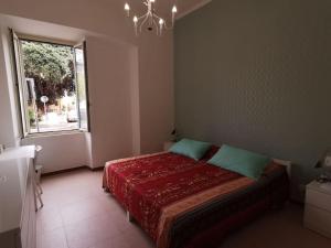- une chambre avec un lit doté d'une couverture rouge et d'une fenêtre dans l'établissement "Erica" Luminoso Trilocale sul Mare, à Anzio