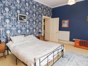 a bedroom with a bed with a blue wall at 3 Forest House in Penrith