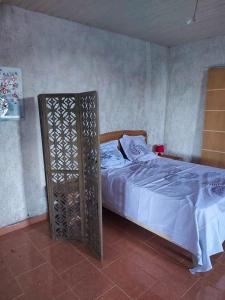 a bedroom with a bed with a white bedspread and a wooden frame at Propriete d'une chambre avec wifi a Petit Bourg a 4 km de la plage in Petit-Bourg