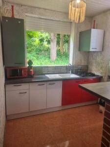 a kitchen with red and white cabinets and a window at Propriete d'une chambre avec wifi a Petit Bourg a 4 km de la plage in Petit-Bourg