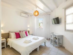 Habitación blanca con cama y TV en BayBees Sea View Residence en Platis Gialos