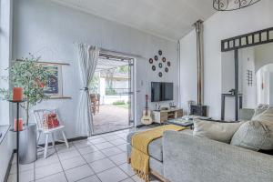 a living room with a couch and a tv at The Spanish House in Centurion