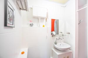 La salle de bains blanche est pourvue d'un lavabo et d'un miroir. dans l'établissement Apartament Domo, à Wrocław