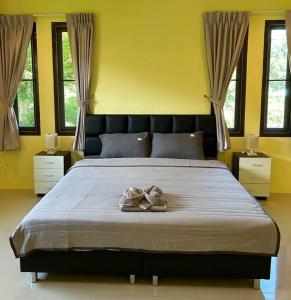 a bedroom with a large bed with two towels on it at Villa Patong in Ban Na Nai