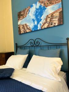 ein Bett mit zwei weißen Kissen und einer blauen Wand in der Unterkunft Cocciu D’amuri in Palermo
