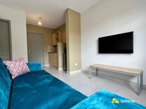 een woonkamer met een bank en een flatscreen-tv bij ADANA PODS in Nairobi