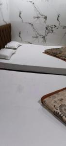 2 łóżka w białym pokoju z materacem w obiekcie Elite hotel w mieście Ujjain
