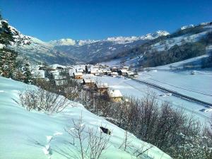 un pueblo en la nieve con montañas en el fondo en Chalet de 5 chambres avec wifi a Aime a 1 km des pistes en Aime La Plagne