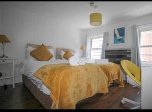Wheatsheaf Hotel في نيوبورت: غرفة نوم بسرير وكرسي اصفر