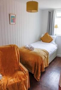 Wheatsheaf Hotel في نيوبورت: غرفة نوم صغيرة بها سرير وكرسي