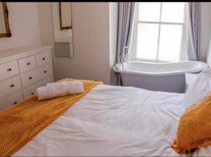 a bedroom with a bed and a tub and a sink at Wheatsheaf Hotel in Newport