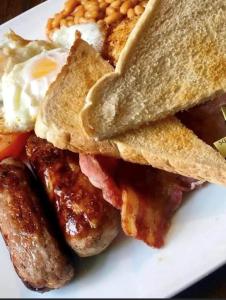 Wheatsheaf Hotel في نيوبورت: طبق من طعام الإفطار مع نقانق البيض والخبز المحمص