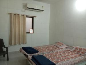 uma cama num quarto com uma janela e um lado lateral da cama em DWARKA BUNGALOW Only Family Full Bungalow em Dwarka