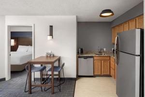 a kitchen with a table and a refrigerator in a room at Residence Inn by Marriott Orlando East/UCF Area in Orlando