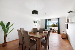 a dining room with a wooden table and chairs at Apartamento Mar a Vista in Portimão